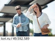 woman waiting for public transport shields eyes from the sun. Стоковое фото, агентство Ingram Publishing / Фотобанк Лори