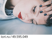 Portrait of a young woman leaning her face against a cold glass table. Стоковое фото, агентство Ingram Publishing / Фотобанк Лори