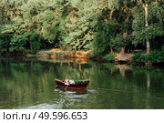 a boat trip for a guy and a girl along the canals and bays of the river overgrown with wild willows. Стоковое фото, агентство Ingram Publishing / Фотобанк Лори