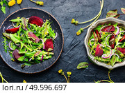 Fresh tasty dandelion,sorrel and beetroot salad on stone table. Spring greens and beetroot salad,top view. Стоковое фото, агентство Ingram Publishing / Фотобанк Лори