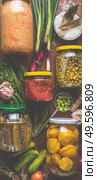 Carious pickled colorful vegetables in jars on wooden background with ingredients, herbs and spices. Copy space. Mock up. Harvest preserving. Fermented  food. Canned vegetables . Top view. Стоковое фото, агентство Ingram Publishing / Фотобанк Лори