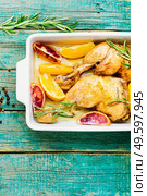 Delicious chicken baked with oranges and rosemary in a baking dish.Baked chicken drumstick. Tasty chicken drumstick baked with oranges. Стоковое фото, агентство Ingram Publishing / Фотобанк Лори