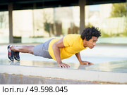 Black man doing push-ups exercising his chest on the grass of an urban park. Fitness, sport, exercising, training and people concept. Black man doing triceps dip exercise on city street bench. Стоковое фото, агентство Ingram Publishing / Фотобанк Лори