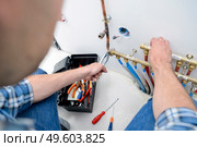 Plumber repairing central piping system. Стоковое фото, агентство Ingram Publishing / Фотобанк Лори