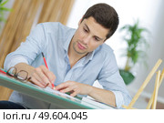 young handsome artist practise drawing as a hobby. Стоковое фото, агентство Ingram Publishing / Фотобанк Лори