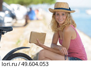 woman wearing a hat relaxing while reading a book. Стоковое фото, агентство Ingram Publishing / Фотобанк Лори