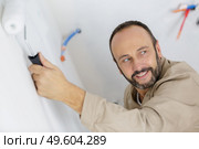 mature tradesman using paint roller. Стоковое фото, агентство Ingram Publishing / Фотобанк Лори