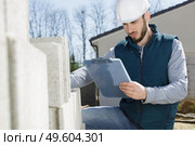 workman with clipboard checking delivery of concrete blocks. Стоковое фото, агентство Ingram Publishing / Фотобанк Лори