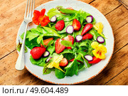Vitamin salad with strawberries,spinach,nasturtium and arugula.Low calorie salad on rustic wooden table. Summer salad with berries and green,vegetarian meal. Стоковое фото, агентство Ingram Publishing / Фотобанк Лори