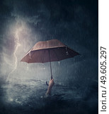 Human hand holding an umbrella sinking in the ocean. Surreal and dramatic scene of person drowning in the sea waters under the storm. Business despair and failure metaphor. Crisis problems concept. Стоковое фото, агентство Ingram Publishing / Фотобанк Лори