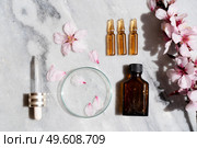 Retinol and almond oil serum beauty care, anti aging natural cosmetic, laboratory testing concept, flat lay over marble background. Retinol and almond oil serum oil beauty care. Стоковое фото, агентство Ingram Publishing / Фотобанк Лори