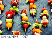 Buffet appetizer of shrimps, jamon, fruits and vegetables.Fresh summer fruit snacks on bamboo skewers. Easy snack from vegetables, fruits, meat and seafood. Стоковое фото, агентство Ingram Publishing / Фотобанк Лори