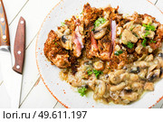 Turkey meat grilled in cheese breading with mushroom sauce. Turkey schnitzel with fried mushrooms. Стоковое фото, агентство Ingram Publishing / Фотобанк Лори