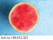 cutted half  part of  ripe  watermelon without pips  around blue background. Стоковое фото, агентство Ingram Publishing / Фотобанк Лори