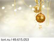 Golden christmas balls garland on glowing silver background. Golden christmas balls. Стоковое фото, агентство Ingram Publishing / Фотобанк Лори