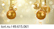 Golden christmas balls garland and evergreen fir tree on glowing golden background. Golden christmas balls. Стоковое фото, агентство Ingram Publishing / Фотобанк Лори