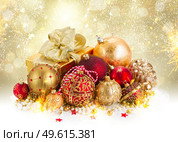 red and golden christmas balls decorations on snow with shing bokeh background, fireworks and golden bokeh background. golden christmas decorations. Стоковое фото, агентство Ingram Publishing / Фотобанк Лори