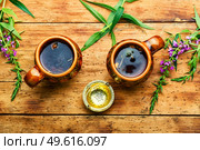 Cup of herbal tea on the table. Ivan tea or fireweed.Herbal medicine. Healing fireweed tea,rustic wooden table. Стоковое фото, агентство Ingram Publishing / Фотобанк Лори