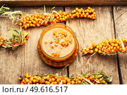 Healthy sea buckthorn jam. Homemade berry jam on an old wooden table. Glass jar with sea buckthorn jam. Стоковое фото, агентство Ingram Publishing / Фотобанк Лори