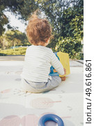 Backview of a baby playing in nature. Стоковое фото, агентство Ingram Publishing / Фотобанк Лори