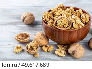 Purified walnuts in a brown wooden bowl on a wooden background. . Стоковое фото, агентство Ingram Publishing / Фотобанк Лори