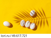 Easter scene with white eggs over illuminating yellow background, palm sunday concept. Easter scene with white eggs. Стоковое фото, агентство Ingram Publishing / Фотобанк Лори