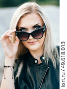 blonde girl in a black trouser suit with blue eyes on the background of a granite quarry from gray rubble. Стоковое фото, агентство Ingram Publishing / Фотобанк Лори