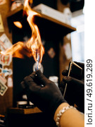 barberman burns razor with fire. Стоковое фото, агентство Ingram Publishing / Фотобанк Лори