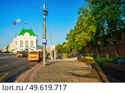 Поливальная машина поливает дорожку у остановки общественного транспорта. Редакционное фото, фотограф Илья Старков / Фотобанк Лори