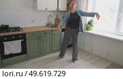 Brunette woman dance, have fun at home listens song, moves to music, feels overjoyed, celebrate good news, relish carefree life looks happy. Young adult female twirls, grooves. Lady dancing in kitchen. Стоковое видео, видеограф Марина Демидюк / Фотобанк Лори