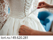dress up the bride in a wedding dress with corset and lacing. Стоковое фото, агентство Ingram Publishing / Фотобанк Лори