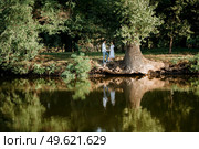 guy and a girl walk along the paths of a forest park between tall trees. Стоковое фото, агентство Ingram Publishing / Фотобанк Лори