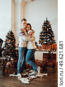 a guy and a girl celebrate the new year togetherin a warm atmosphere and give each other gifts. Стоковое фото, агентство Ingram Publishing / Фотобанк Лори