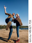 Guy and girl in caged shirts and trekking shoes on granite rocks. Стоковое фото, агентство Ingram Publishing / Фотобанк Лори