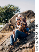 Guy and girl in caged shirts and trekking shoes on granite rocks. Стоковое фото, агентство Ingram Publishing / Фотобанк Лори