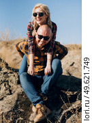 Guy and girl in caged shirts and trekking shoes on granite rocks. Стоковое фото, агентство Ingram Publishing / Фотобанк Лори