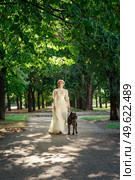Girl in an old dress with ruffles and a big dark dog. Стоковое фото, агентство Ingram Publishing / Фотобанк Лори