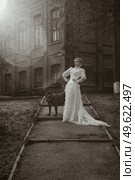 Girl in an old dress with ruffles and a big dark dog. Стоковое фото, агентство Ingram Publishing / Фотобанк Лори