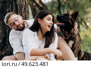 Big dog for a walk with a guy and a girl on the green prairie. Стоковое фото, агентство Ingram Publishing / Фотобанк Лори