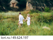 a guy with a girl in light clothes on the background of a green canyon of erosion of the earth. Стоковое фото, агентство Ingram Publishing / Фотобанк Лори