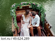 a boat trip for a guy and a girl along the canals and bays of the river overgrown with wild willows. Стоковое фото, агентство Ingram Publishing / Фотобанк Лори