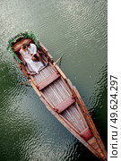 a boat trip for a guy and a girl along the canals and bays of the river overgrown with wild willows. Стоковое фото, агентство Ingram Publishing / Фотобанк Лори