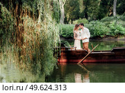 a boat trip for a guy and a girl along the canals and bays of the river overgrown with wild willows. Стоковое фото, агентство Ingram Publishing / Фотобанк Лори