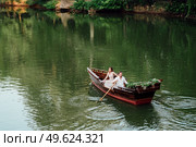 a boat trip for a guy and a girl along the canals and bays of the river overgrown with wild willows. Стоковое фото, агентство Ingram Publishing / Фотобанк Лори