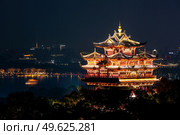 Night view of illuminated Cheng Huang Ge (City God Pavillion) with West Lake and city skyline on background, Hangzhou, China. Night view of illuminated Cheng Huang Ge, also known as City God Pavillion, Hangzhou, China. Стоковое фото, агентство Ingram Publishing / Фотобанк Лори