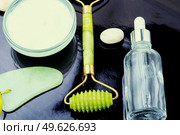 Cosmetic face cream and face roller. Massage quartz roller for the face. Cosmetic face cream. Стоковое фото, агентство Ingram Publishing / Фотобанк Лори