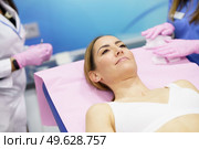 Middle-aged woman lying on the stretcher in an aesthetic clinic waiting for a botulinum toxin treatment.. Middle-aged woman lying on the stretcher in an aesthetic clinic. Стоковое фото, агентство Ingram Publishing / Фотобанк Лори