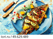 Roasted river carp with fruits, berries and spices.. Delicious carp fried with kiwi and mango. Стоковое фото, агентство Ingram Publishing / Фотобанк Лори