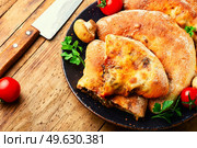 Calzone, a closed pie with vegetable filling. Dish of italian cuisine. Calzone - Italian pie, pizza. Стоковое фото, агентство Ingram Publishing / Фотобанк Лори