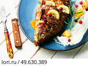 Appetizing baked carp fish with cranberries, kiwi and mango. Grilled fish. Baked carp with fruits. Стоковое фото, агентство Ingram Publishing / Фотобанк Лори